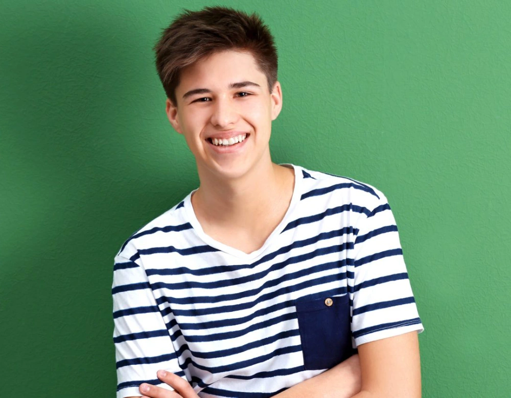 Boy smiling with green background